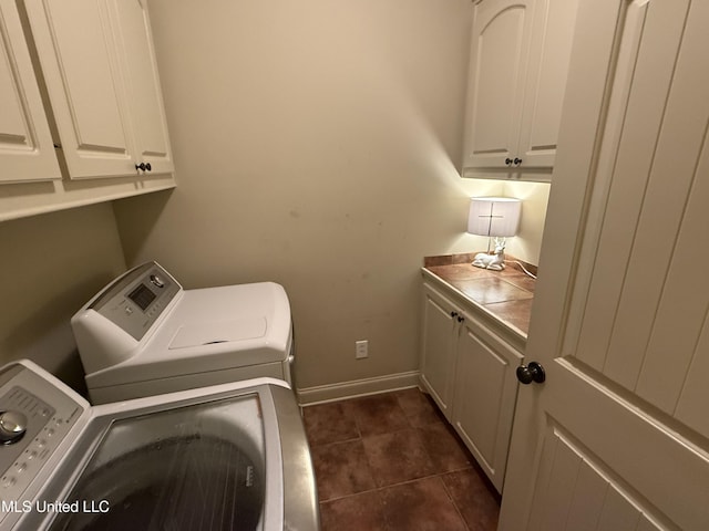 104 Belle Oak Dr, Brandon, MS 39042 - laundry room featuring separate washer and dryer, cabinet space, baseboards, and dark tile patterned flooring