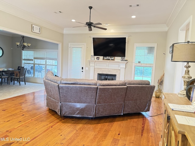 128 Charlton Dr, Madison, MS 39110 - living room featuring a ceiling fan, a chandelier, light wood-style floors, a tile fireplace, and plenty of natural light