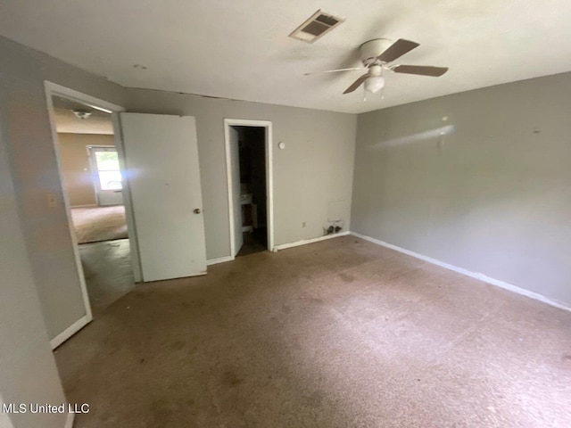 carpeted empty room with baseboards, a ceiling fan, and visible vents