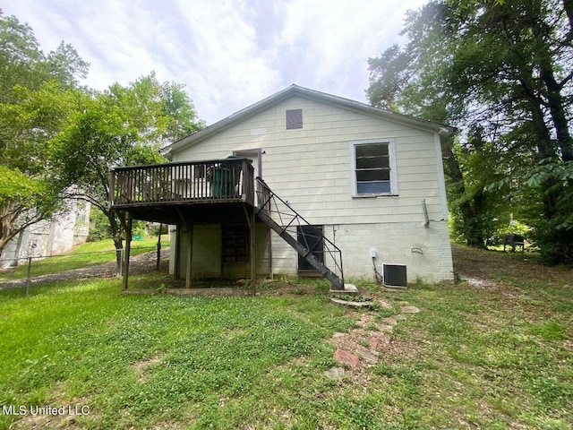 rear view of property featuring fence, a wooden deck, a yard, and stairs
