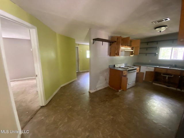 kitchen featuring open shelves, white gas range, dark floors, under cabinet range hood, and visible vents