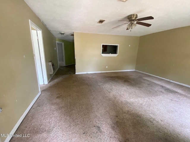 carpeted spare room with baseboards, a ceiling fan, and visible vents