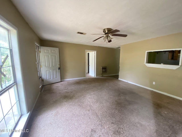 unfurnished room featuring visible vents, a ceiling fan, baseboards, and heating unit