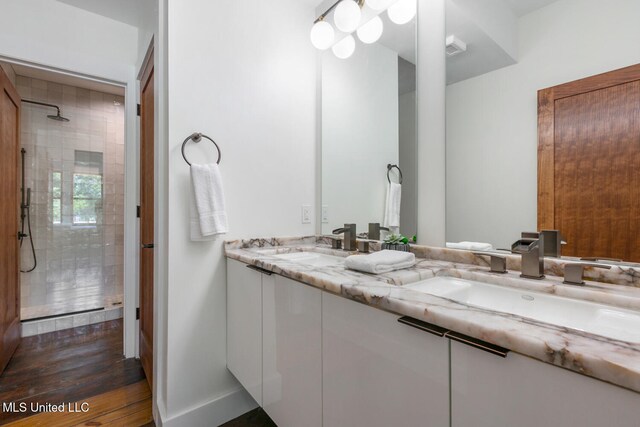301 S Toulme St Unit 201, Bay Saint Louis, MS 39520 - bathroom featuring hardwood / wood-style floors, vanity, and tiled shower