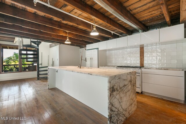 301 S Toulme St Unit 201, Bay Saint Louis, MS 39520 - kitchen featuring a center island with sink, gas stove, and white cabinetry