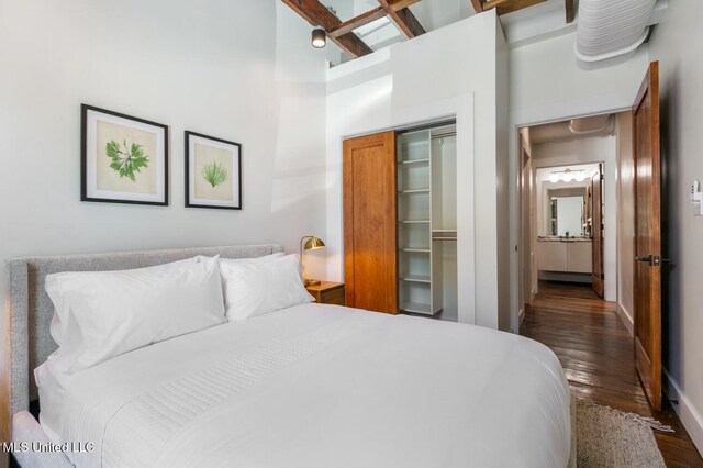 301 S Toulme St Unit 201, Bay Saint Louis, MS 39520 - bedroom featuring ceiling fan, a towering ceiling, beamed ceiling, dark hardwood / wood-style flooring, and a closet