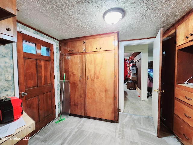 entrance foyer with a textured ceiling and ornamental molding