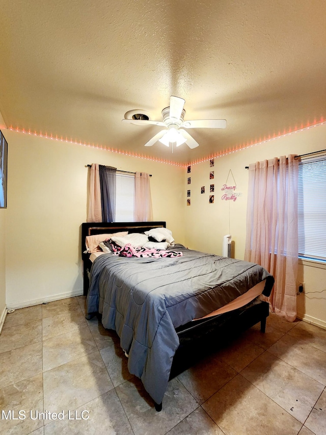 tiled bedroom featuring ceiling fan and a textured ceiling