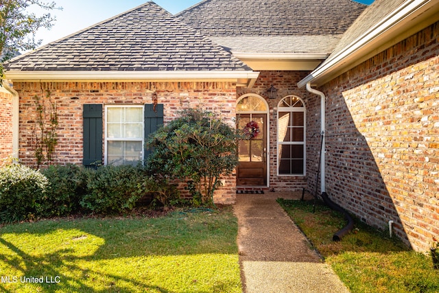 property entrance with a lawn