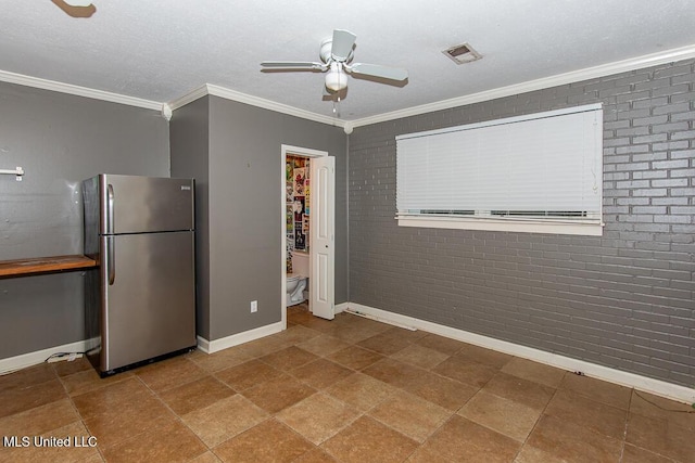 1777 Brecon Dr, Jackson, MS 39211 - kitchen featuring freestanding refrigerator, ceiling fan, baseboards, crown molding, and brick wall