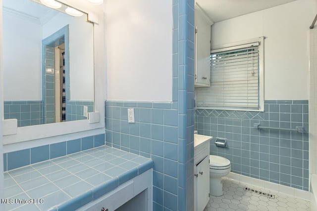 1777 Brecon Dr, Jackson, MS 39211 - bathroom featuring tile walls, vanity, toilet, tile patterned floors, and wainscoting