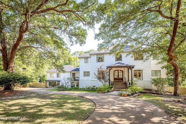 view of front of house featuring fence, stucco siding, and french doors