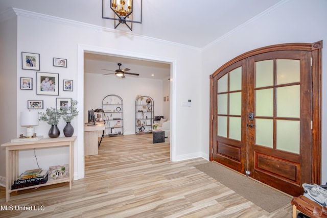 foyer featuring wood finished floors, french doors, ceiling fan with notable chandelier, baseboards, and ornamental molding