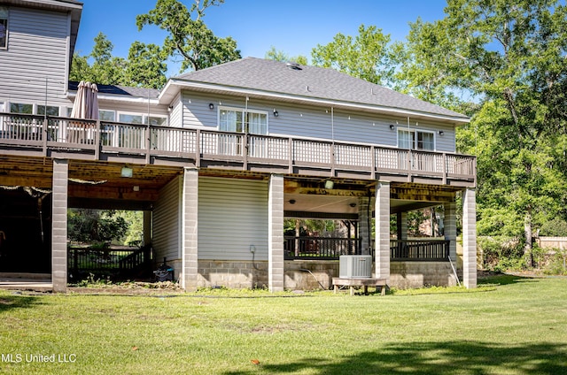 rear view of property featuring a yard, a deck, cooling unit, and a shingled roof