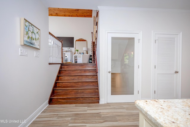 stairway with baseboards, beam ceiling, and wood finished floors