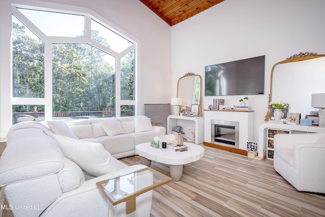 living area with a glass covered fireplace, high vaulted ceiling, wood ceiling, and wood finished floors