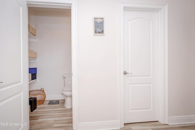 bathroom featuring toilet, baseboards, and wood finished floors