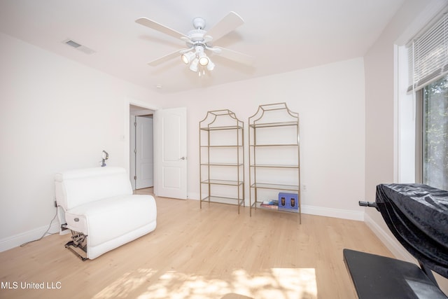 living area with light wood finished floors, baseboards, ceiling fan, and visible vents