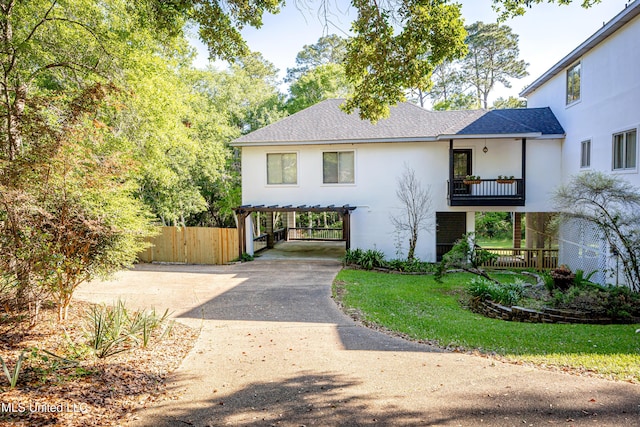 modern farmhouse style home with roof with shingles, fence, a balcony, concrete driveway, and stucco siding