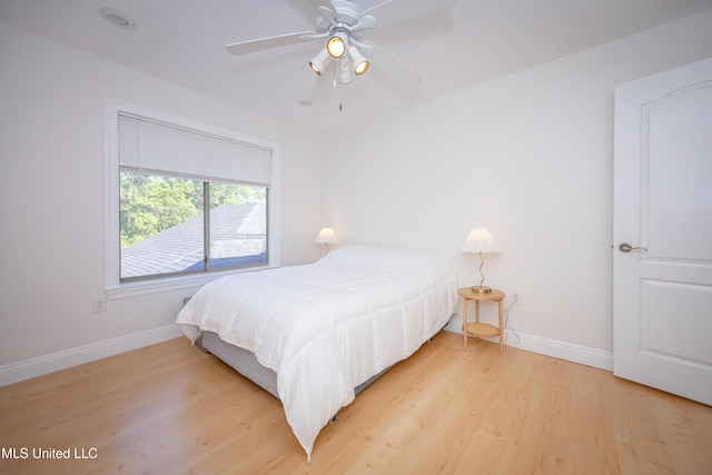 bedroom with light wood finished floors, baseboards, and a ceiling fan