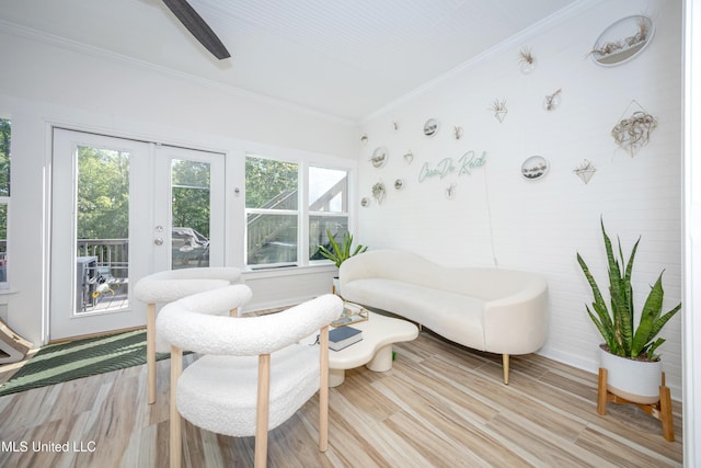 interior space featuring light wood-style floors, french doors, a ceiling fan, and ornamental molding