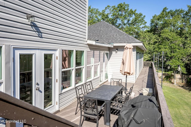 wooden deck featuring a yard, french doors, outdoor dining area, and fence