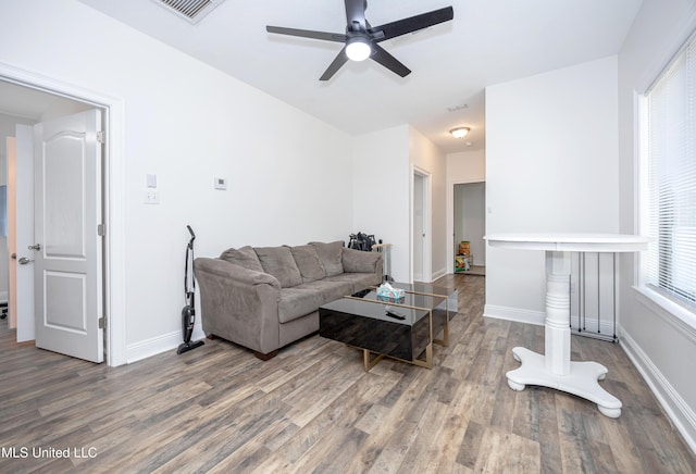 living room featuring wood finished floors, baseboards, and ceiling fan