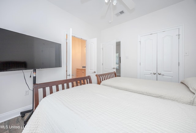 bedroom featuring a closet, baseboards, ceiling fan, visible vents, and wood finished floors