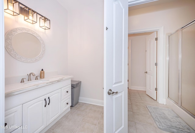 bathroom with a stall shower, baseboards, tile patterned floors, and vanity
