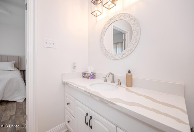 ensuite bathroom with vanity, ensuite bathroom, and wood finished floors