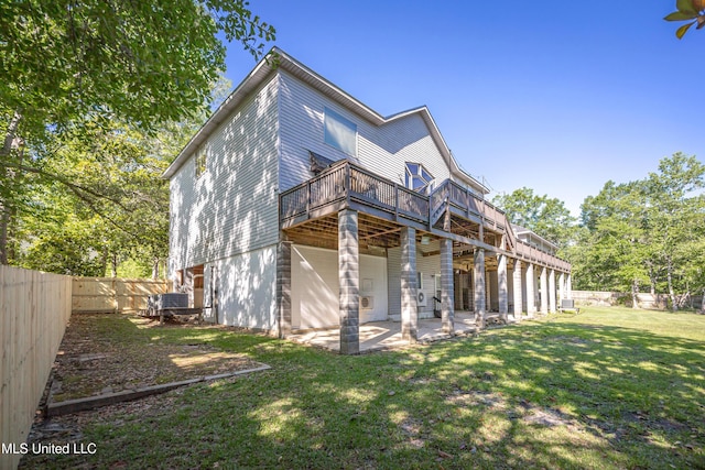 rear view of property with a fenced backyard, a deck, a patio area, and a lawn
