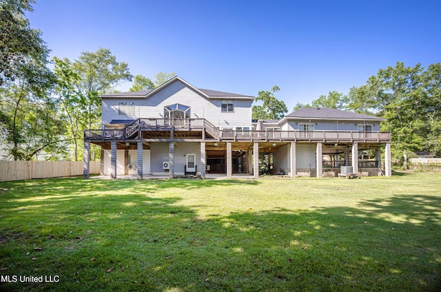 back of house featuring a deck, stairs, fence, and a lawn