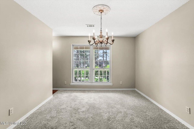 unfurnished room featuring a textured ceiling, a chandelier, and carpet flooring