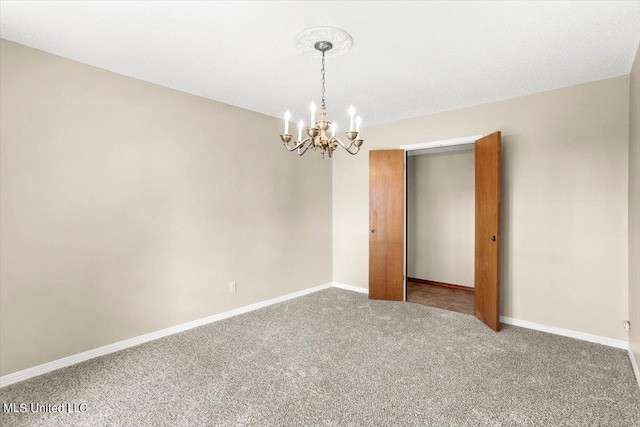 carpeted spare room with a notable chandelier