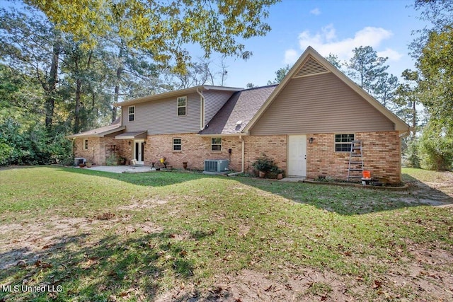 rear view of house featuring central AC unit and a lawn