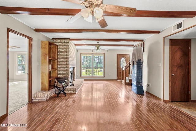 interior space with beam ceiling, wood-type flooring, and a wealth of natural light