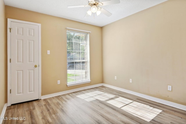 empty room featuring a textured ceiling, light hardwood / wood-style floors, and ceiling fan