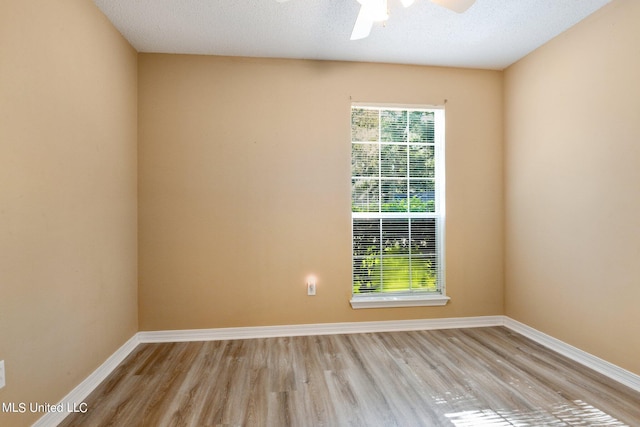 spare room with ceiling fan, a textured ceiling, and light wood-type flooring