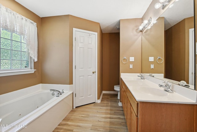 bathroom with toilet, a tub to relax in, hardwood / wood-style flooring, and vanity