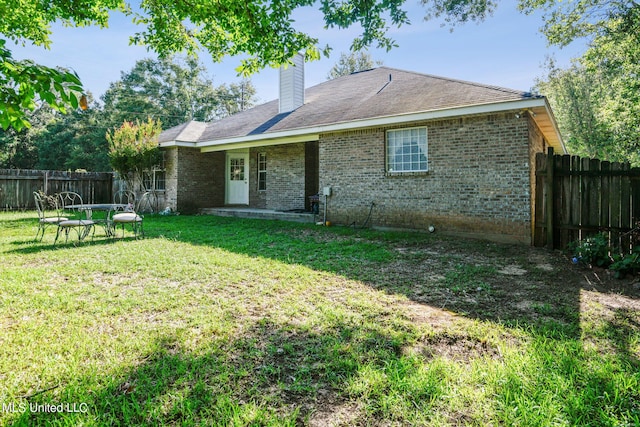 back of property featuring a patio and a lawn