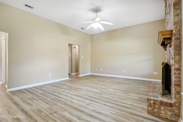 unfurnished living room featuring a textured ceiling, ceiling fan, a fireplace, and light wood-type flooring