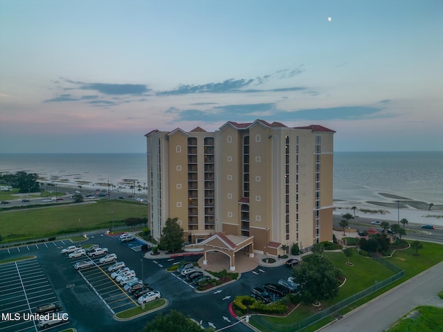 view of property featuring uncovered parking and a water view