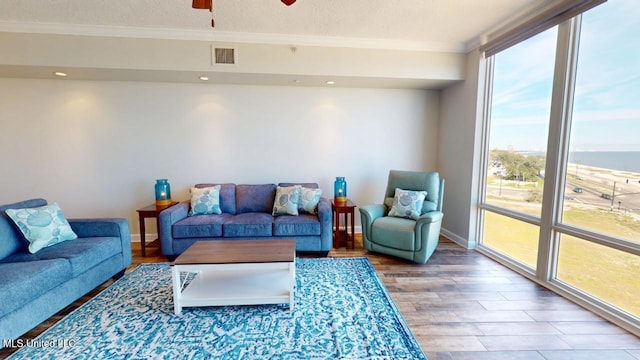 living room with visible vents, ceiling fan, wood finished floors, crown molding, and a textured ceiling