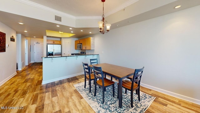 dining space with light wood-style floors, recessed lighting, ornamental molding, and baseboards