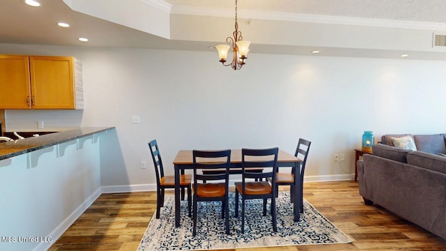 dining room with baseboards, ornamental molding, wood finished floors, and recessed lighting