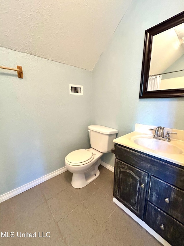 31019 N 19th Hwy, West, MS 39192 - bathroom with vaulted ceiling, toilet, baseboards, and visible vents
