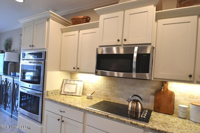 kitchen featuring white cabinetry, appliances with stainless steel finishes, and ornamental molding