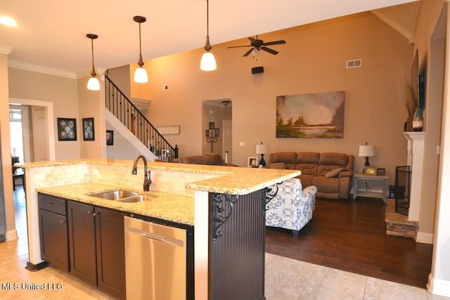 kitchen with an island with sink, open floor plan, stainless steel dishwasher, pendant lighting, and a sink