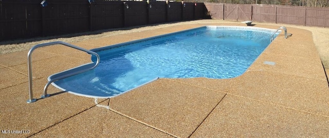 view of swimming pool featuring a fenced in pool, a fenced backyard, and a diving board