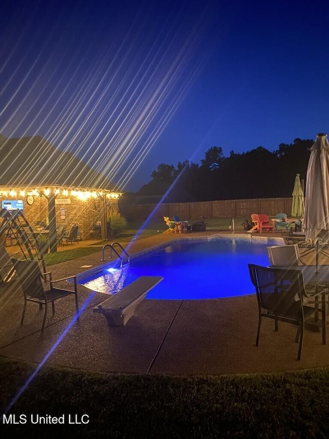 pool at twilight featuring a patio, a fenced backyard, and a fenced in pool